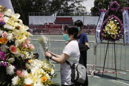 Dos mujeres colocan flores en el memorial a las víctimas de Tiananmen, en Hong Kong.-Foto:   Kin Cheung / AP / KIN CHEUNG