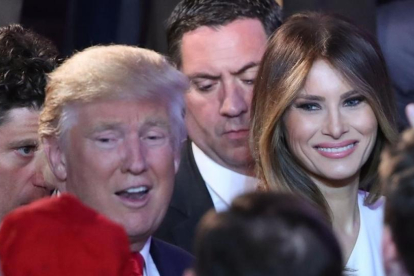 Trump y su mujer, Melania, felicitados por la multitud tras el discurso de aceptación de la victoria del magnate, en el hotel New York Hilton Midtown, en Nueva York, el 9 de noviembre.-AFP / MARK WILSON