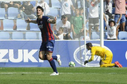 Melero, atacante del Huesca, celebra el único gol del partido mientras Masip se encuentra de rodillas al lado del balón.-LOF