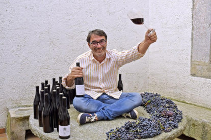 Jaime Díaz, con sus vinos y varios racimos de garnacha, cimiento varietal de su trabajo en Cebreros.-ARGICOMUNICACIÓN