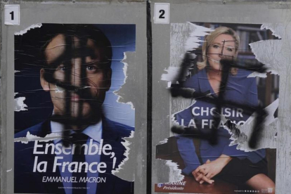 Pintadas en carteles electorales de Macron y Le Pen.-AFP / DAMIEN MEYER