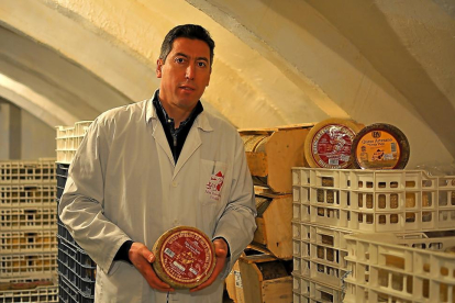 Pablo Alonso  muestra uno de sus quesos en la bodega de conservación. Se realizan con leche de oveja seleccionada. La empresa familiar tiene 50 años de historia.-H.M.
