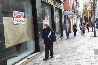 Un viandante pasa ante un negocio cerrado en una céntrica calle de Valladolid. J.M. LOSTAU