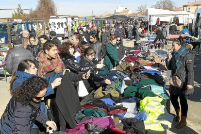 Varias personas observan las prendas de un puesto en el mercadillo de Medina del Campo-J.M.Lostau
