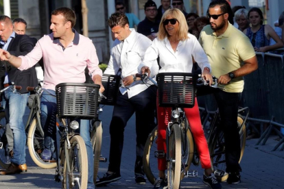 El presidente Macron y su esposa, Brigitte, dan un paseo en bicicleta, el pasado miércoles en Le Touquet.-EL PERIÓDICO