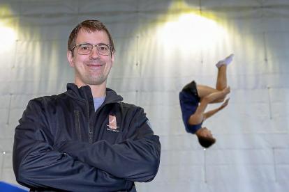 Miguel Vicente posa en el polideportivo Antonio Garnacho con un gimnasta al  fondo.-J.M. LOSTAU