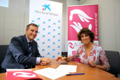 El presidente de la oficina de La Caixa de la calle Embajadores, Juan Manuel Descombes, y la presidenta de Aclad, María Gutiérrez-Cortines, firman la donación de 5.000 euros para la asociación-Ical