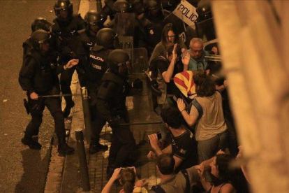 Los antidisturbios de los Mossos contienen a manifestantes en la Vía Laietana de Barcelona, junto a la comisaría de la Policía Nacional.-FERRAN NADEU