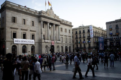 Una pancarta el lema "Més Democràcia" , cuelga de la fachada del Ayuntamiento de Barcelona.-EFE