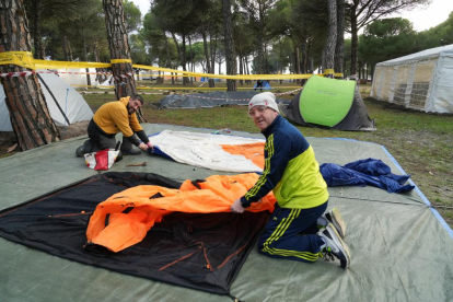 Dos participantes mientras colocan sus enseres para dormir en la concentración Motauros en Tordesillas, Valladolid -J.M. LOSTAU