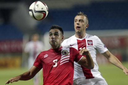 Chipolina, de Gibraltar, vestido de rojo, y el polaco Grosicki, en el partido jugado este domingo en Faro (Potugal).-Foto: AP / FRANCISCO SECO
