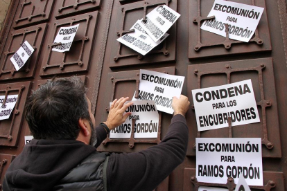 Un manifestante coloca carteles pidiendo la excomunión de RamosGordón y la condena para los encubridores en Astorga.-ICAL
