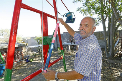 Jesús Españadero muestra el mecanismo que ha patentado para impulsar el columpio desde el lateral en el patio de su vivienda en Valladolid.-J. M. LOSTAU