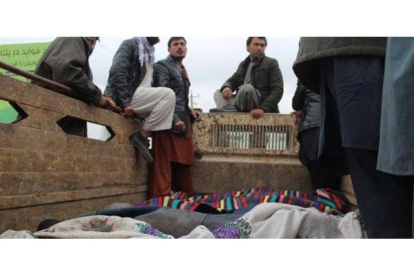 Un grupo de afganos trasladan los cuerpos de las 13 víctimas civiles asesinadas en Kunduz.-EFE