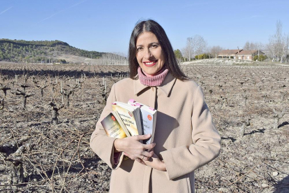 Mayra, con los tres libros que componen su trilogía La vida de Carla en un viñedo de Tudela de Duero, la localidad en la que reside.-