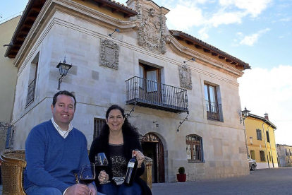 Enrique y Olga, con su tinto cigaleño, ante la fachada del palacio del siglo XVIII, hoy convertido en complejo hostelero en Valoria.-ARGI