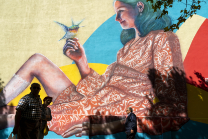 Una mujer sostiene un pájaro en uno de los 'Murales de la Felicidad' para reflejar la biodiversidad de Pajarillos. ICAL
