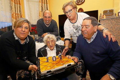 Bernarda sujetando la tarta de su cumpleaños acompañada por su hija, su yerno y dos de sus nietos .-J.M. LOSTAU