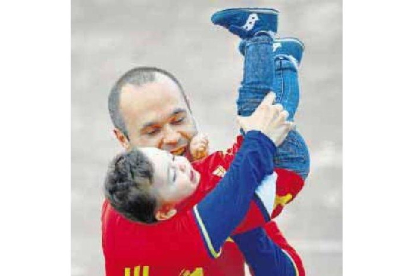 Iniesta juega con su niño en el entrenamiento de ayer.-AP