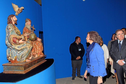 La Reina Sofía, acompañada por el presidente Herrera,  contempla una de las obras expuestas en la muestra.-CASA REAL