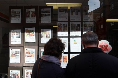 Una pareja mira los anuncios de una inmobiliaria en Valladolid-Ical