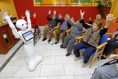 Un grupo de mayores utiliza el robot en las instalaciones de la residencia Lacort ubicada en la localidad vallisoletana de Viana de Cega.-J. M. LOSTAU