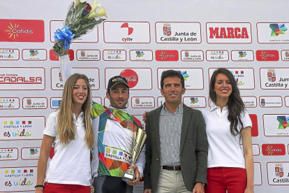 El vencedor de la Vuelta a Castilla y León posa en el podio junto al director general de Deportes de la Junta, Alfonso Lahuerta, y dos azafatas-ICAL