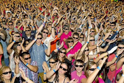 Miles de personas bailan al ritmo de la música durante el ataque al récord Guiness del máximo número de personas con gafas de sol ayer a primera hora de la noche en la Acera de Recoletos.-J. M. Lostau