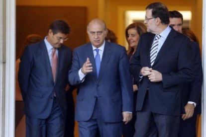 El ministro Jorge Fernández Díaz habla con Mariano Rajoy, a las puertas de la Moncloa, el pasado 3 de octubre.-