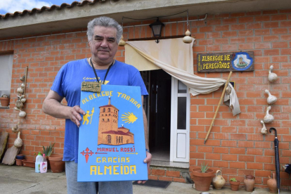 El hospitalero zamorano José Almeida, en el albergue de peregrinos de Tábara, que gestiona desde hace cuatro años, con una placa de agradecimiento enviada por un peregrino, después de pernoctar allí en su ruta hacia Santiago.-ARGICOMUNICACIÓN