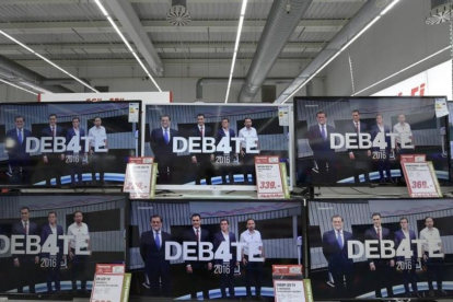 Televisores de un centro comercial ofreciendo el debate a cuatro que emitieron el lunes, 13 de junio, 17 televisiones de toda España simultáneamente.-ELOY ALONSO