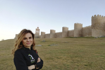 Gemma Rodríguez, ataviada con un delantal de Ávila Auténtica, delante de la imponente muralla romana abulense.-