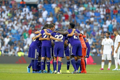 Los jugadores del Real Valladolid hacen su habitual piña, antes del comienzo de la segunda parte frente al Real Madrid, con Isco y Benzema al fondo.-PHOTO-DEPORTE