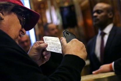 Michael Moore, con la nota que entregó en la Trump Tower de Nueva York.-AFP / YANA PASKOVA