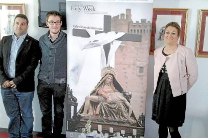 Rubén Mena, José María Magro y Teresa López ayer, junto al cartel promocional de la Semana Santa en inglés-El Mundo