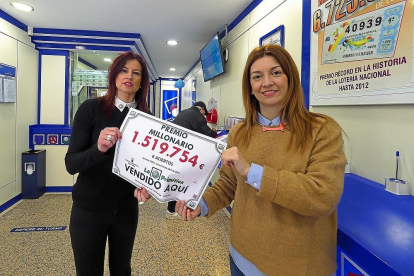 Marta y Patricia muestran un cartel que anuncia el boleto millonario sellado en la Administración de la calle Santa María de Tordesillas.-MIGUEL ÁNGEL SANTOS
