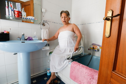 Juana Macay, en el baño de su casa, con los aparatos adaptados para el aseo. / J.M. LOSTAU