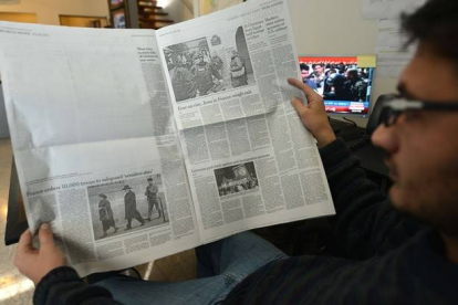 Un paquistaní lee la edición local de 'The New York Times', en la que ha sido eliminada la información sobre 'Charlie Hebdo', este miércoles en Islamabad.-Foto: AFP / AAMIR QURESHI