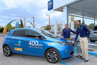 Eduardo Bustillo y Pablo Rodríguez recargan su Renault Zoe eléctrico con el que desarrollarán su viaje.-EL MUNDO