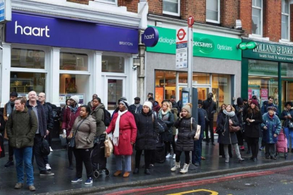 Viajeros hacen cola en la parada para acceder a los autobuses, en Brixton, en el sur de Londres, este lunes.-AFP / NIKLAS HALLE'N