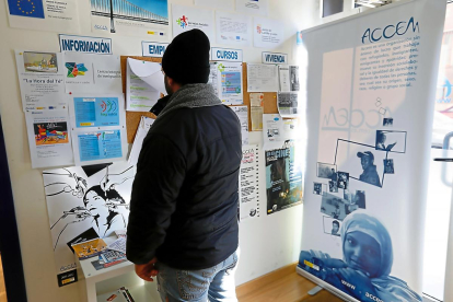 Un refugiado consulta el tablón de anuncios en la sede de la asociación accem-J.M. LOSTAU