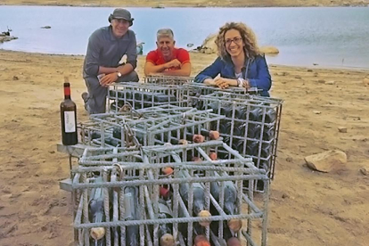 Los hermanos Luis, Enrique y Almudena Castelló con las botellas recién extraídas del agua.-L.P.