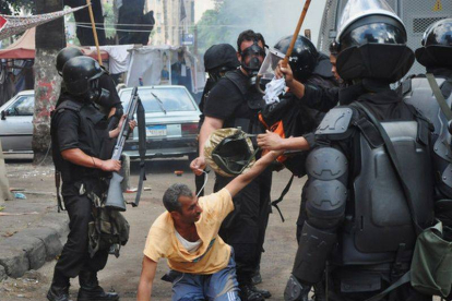 Imagen de las fuerzas de seguridad deteniendo a un simpatizante de Mohammed Mursi el 14 de agosto de 2013.-Foto: AP