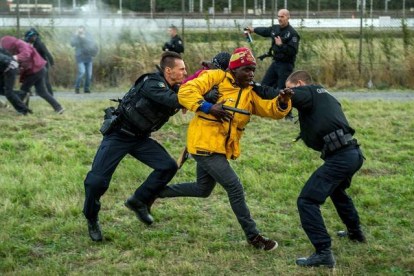 Policías franceses intentan parar a los inmigrantes que buscan colarse al Eurotúnel en Calais este miércoles.-AFP/PHILIPPE HUGUEN