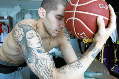 NachoMartín luce tatuajes, entre ellos el dedicado a su padre Morti (arriba) mientras posa con el balón de baloncesto.-J.M. LOSTAU