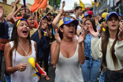 Varias jóvenes gritan consignas contra el presidente Maduro, en Los Teques (Estado de Miranda, Venezuela), este miércoles.-AFP / RONALDO SCHEMIDT