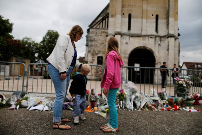 Una madre y sus hijos dejan flores ante la iglesia de Saint-Etienne-du-Rouvray.-CHARLY TRIBALLEAU / AFP