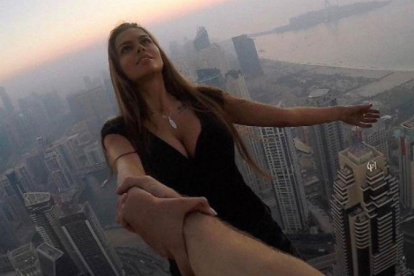 Viki Odintcova, de la mano de su asistente, sin arnés, a 300 metros de altura, a punto de hacerse un selfi de vértigo.-