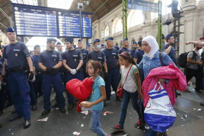 Una familia de refugiados deja la estación más importante de este de Budapest, después de que la policía la cerrara impidiédoles el paso con una valla humana.-REUTERS / LASZLO BALOGH