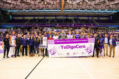 Jugadores, árbitros y oficiales de mesa del partido UEMC Real Valladolid-Ourense de LEB-Oro, con la pancarta de 'YoDigoCero'. / EL MUNDO